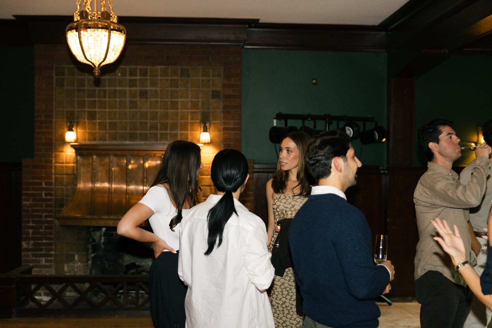 Guests in conversation by the fireplace at The Baillie